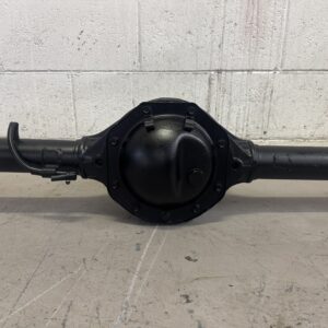 A FORD FALCON BA SALOON & UTE RECONDITIONED EXCHANGE DIFF with a round central housing and axle tubes sits on a concrete floor in front of a white-painted breeze block wall.