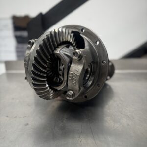 A close-up of the Import placeholder for 1804 metal differential gear assembly on a metallic surface, highlighting detailed gear teeth and components, with a blurred workshop in the background.