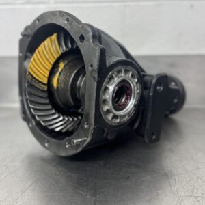 A close-up of Import placeholder for 2012’s differential gear assembly on a metallic surface, yellow marking compound on the gear teeth for inspection, with a white tiled wall in the background.