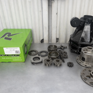 A Toyota Altezza/JZX 7.5" TRD 2 way Rebuilt Diff and metal gears are arranged on a grey workbench in a workshop with a corrugated metal wall in the background.