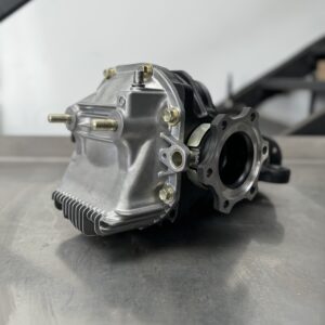 Close-up of a Nissan GT-R (BNR33/34) Rebuilt Rear Diff 4.11 Cusco 1.5 Way on a smooth metal surface, with an out-of-focus industrial background.