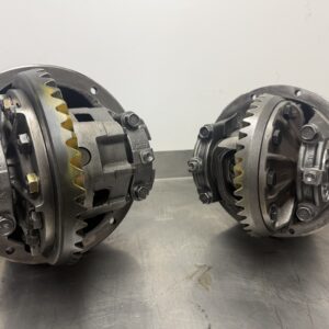 Two Toyota Land Cruiser 80 Series Front & Rear Differentials (4.56 Ratio) with exposed gears are displayed on a metallic surface against a plain background, clearly showing internal components and gear teeth.