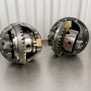 Two Nissan Safari / Patrol H233B 4.625 front and rear diffs with visible gears are side by side on a metallic surface, set against vertical white panels.
