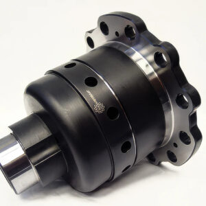 A close-up of a black metal automotive differential with multiple circular holes and a polished silver edge, photographed against a plain white background.